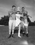 Majorette Posing with Football Players by East Texas State Teachers College