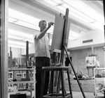 Painting Student Seen Through Art Building Windows by East Texas State College